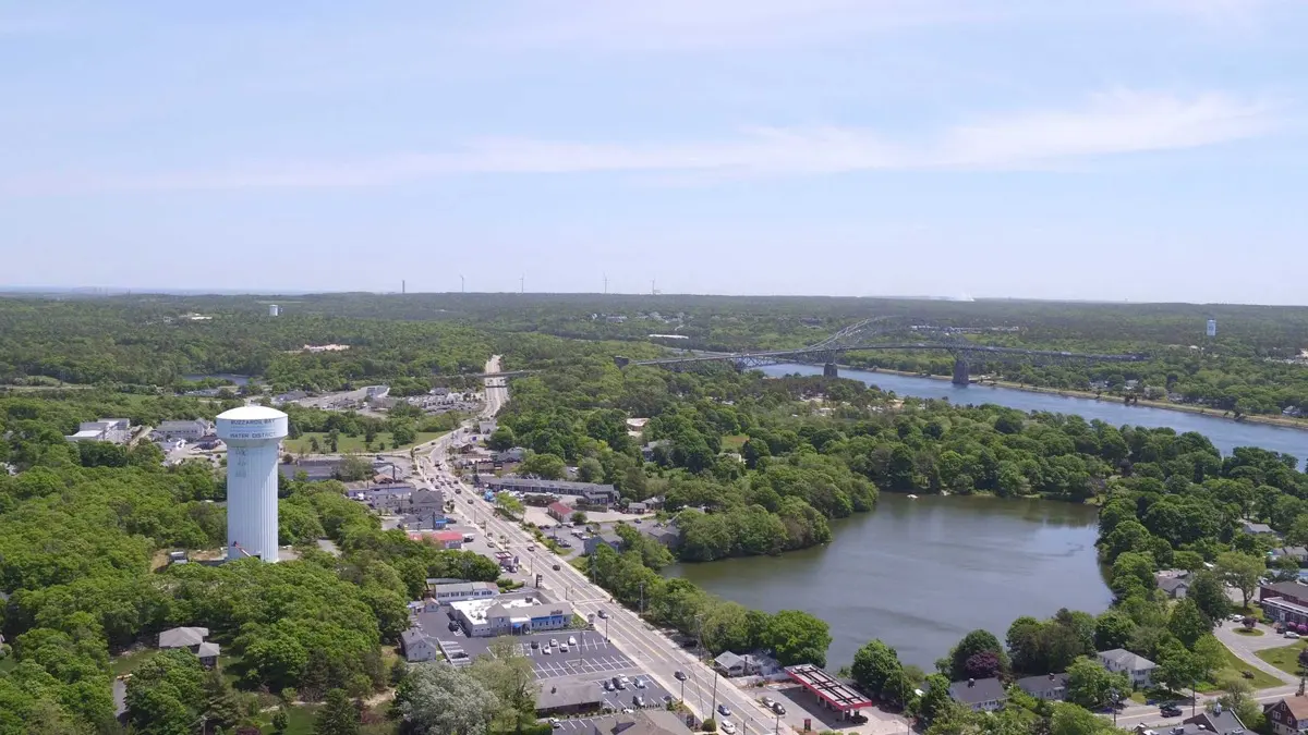 Aerial view of the town, tree line and Cape Cod Canal bridge